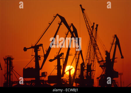 Es gibt lila Sonnenuntergang im Hafen. Es gibt Hafenkrane und Mechanismen. Stockfoto