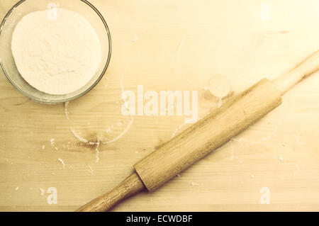 Schneidebrett mit einem Nudelholz und eine Schüssel mit Mehl Stockfoto