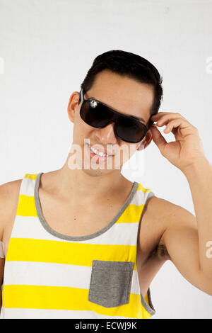 Hübscher Hispanic Mann in gelb und weiß abgestreift Tank-Top, suchen glücklich mit Sonnenbrille Stockfoto