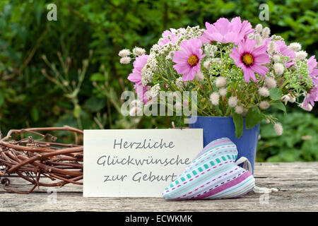 Deutsche Grußkarte mit pinkfarbenen Sommerblumen und Text: Gratulation zur Geburt Stockfoto