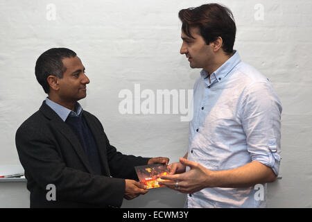 Kopenhagen, Dänemark. 20. Dezember 2014. Dr. Ahmed Shaheed, UN Assistant General Secretary & Sonderberichterstatter zur Lage der Menschenrechte im Iran (Foto, links) erhält bei einem Festakt in Kopenhagen den neuen Dokumentarfilm "Wir sind Journalisten" von iranischen Exil, Herr Ahmad Farahani (Foto, rechts). Farahani wurde 3 Mal inhaftiert und nach schwerer Folter während der Erstellung seines Films über den rauen Bedingungen für Journalismus im Iran. Bildnachweis: OJPHOTOS/Alamy Live-Nachrichten Stockfoto