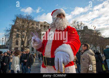 London, UK. 20. Dezember 2014.  Santas trotzt der Schwerkraft auf dem Trafalgar Square unterhalten Touristen Credit: Velar Grant/ZUMA Wire/ZUMAPRESS.com/Alamy Live News Stockfoto