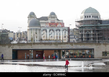 Bradford City Park, Centenary Square mit Kind planschen im Spiegel Teich und Alhambra Theatre im Hintergrund Stockfoto