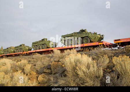 Armee-Mannschaftswagen und anderen Militärfahrzeugen an Bord eine Fracht trainieren gehen Süden durch Zentral-Oregon. Stockfoto