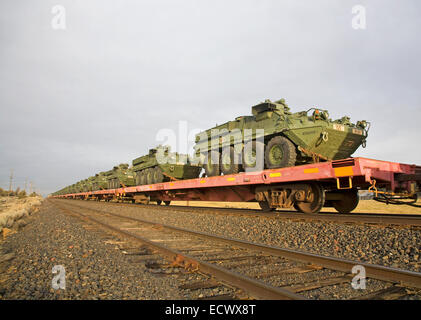 Armee-Mannschaftswagen und anderen Militärfahrzeugen an Bord eine Fracht trainieren gehen Süden durch Zentral-Oregon. Stockfoto