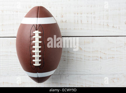 Closeup Overhead Schuss von einem amerikanischen College Stil Fußball auf einem weiß getünchten Holztisch. Der Ball ist ausgeglichen ot links mit Stockfoto