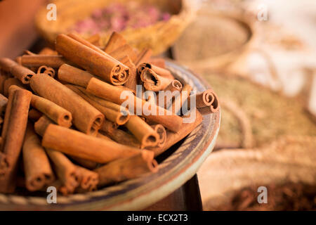 Zimt-sticks auf Teller und andere Gewürze im Hintergrund im Gewürzmarkt Stockfoto