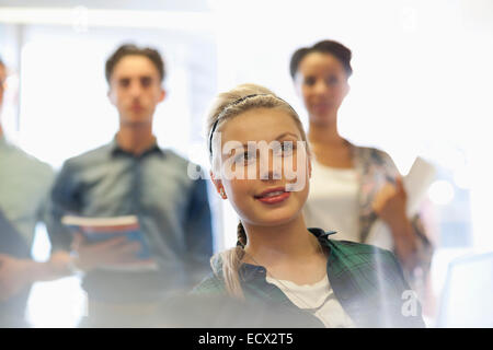 Vier Studenten im Klassenzimmer lächelnd Stockfoto