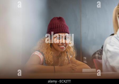 Porträt des Lächelns weibliche Studentin aufschreiben von Notizen im Klassenzimmer Stockfoto