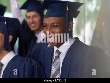 Lächelnde Studenten stehen im Freien während der Abschlussfeier Stockfoto