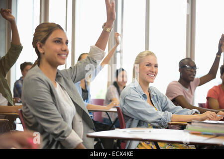 Studenten, die Hände erhebend, während seminar Stockfoto