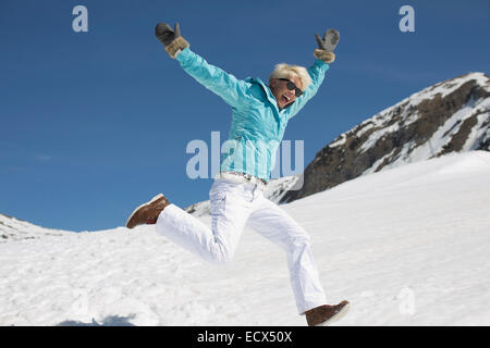 Üppige Frau spielt im Schnee Stockfoto