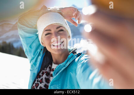 Glückliche Frau nehmen Selfie im Schnee Stockfoto