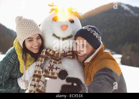 Paar nehmen Selfie mit Schneemann Stockfoto