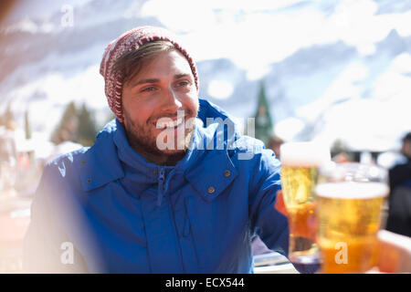 Lächelnder Mann in warme Kleidung Biertrinken im freien Stockfoto