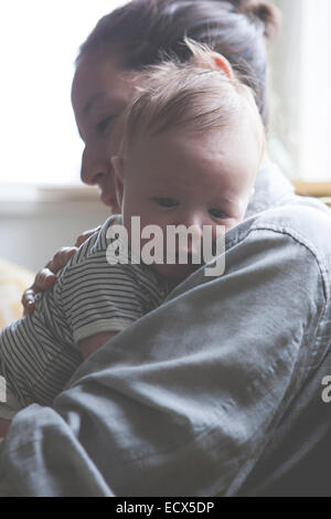 Porträt der Mutter hält kleine Baby in gestreiften t-shirt Stockfoto