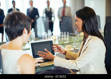 Unternehmerinnen mit Tablet-pc im Konferenzraum sitzen Stockfoto
