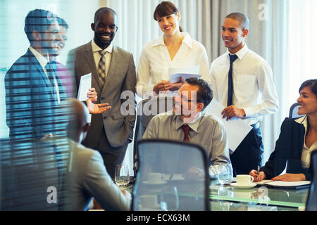 Geschäftsleute, die lächelnd im Konferenzraum im Business-meeting Stockfoto