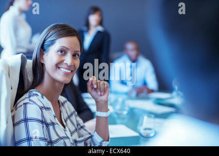 Porträt von Mitte adult Geschäftsfrau sitzen im Konferenzraum und wegsehen Stockfoto