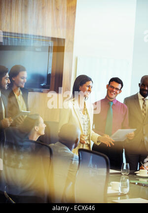 Gruppe von Geschäftsleuten lächelnd und diskutieren im Konferenzraum Stockfoto