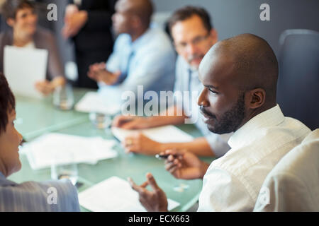 Unternehmer im Gespräch mit Kollegen während Geschäftstreffen im Konferenzraum Stockfoto