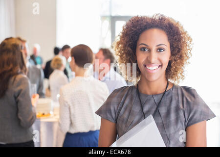 Portrait von junge Geschäftsfrau stehend und lächelnd in Büro Halle Stockfoto