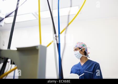 Junge weibliche Krankenschwester, die Steuerung von medizinischen Geräten während der Operation Stockfoto