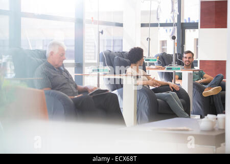 Patienten in Sesseln, die medizinische Behandlung im Krankenhaus Stockfoto