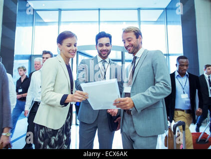 Porträt der Geschäftsfrau und zwei Geschäftsleute stehen in der Lobby des Konferenzzentrum Stockfoto