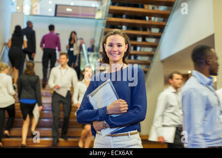 Porträt der lächelnde junge Frau steht in der Lobby des Konferenzzentrum Stockfoto