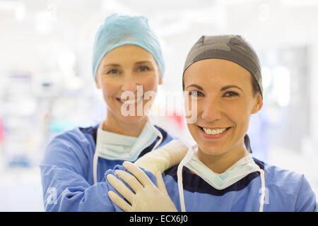 Porträt von zwei weiblich lächelnd Ärzte tragen chirurgische Kappen im Operationssaal Stockfoto