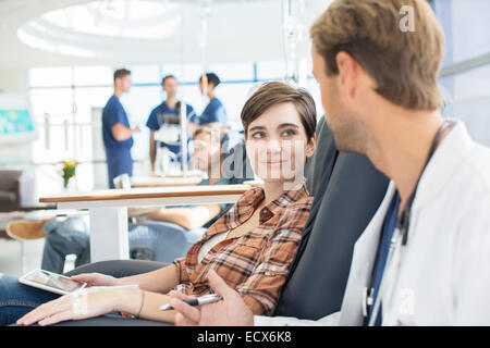 Arzt im Gespräch mit Patienten in medizinischer Behandlung in Ambulanz Stockfoto