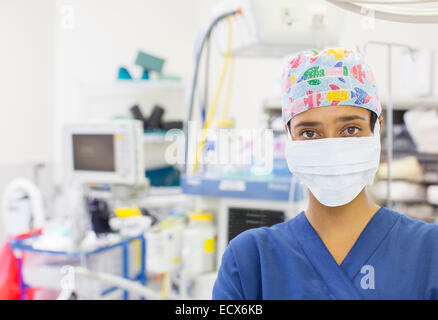 Porträt von Krankenschwester tragen bunte OP-Cap und Maske im Operationssaal Stockfoto