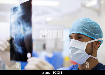 Nahaufnahme des Chirurgen tragen OP-Cap und Maske Blick auf Röntgen im OP-Saal Stockfoto