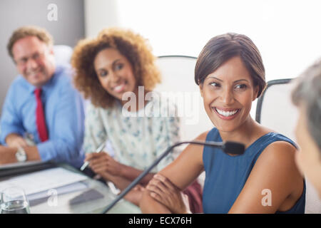 Porträt von lächelnden Frau sitzt am Konferenztisch