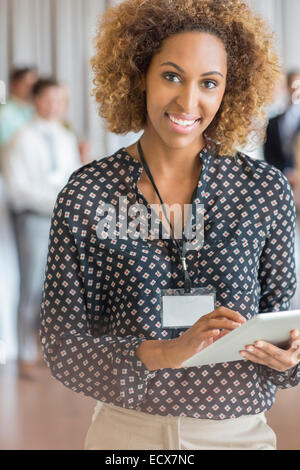 Portrait der schönen Frau mit braunen lockigen Haaren halten digital-Tablette Stockfoto