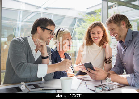 Geschäftsleute, die mit Handy im Büro treffen Stockfoto