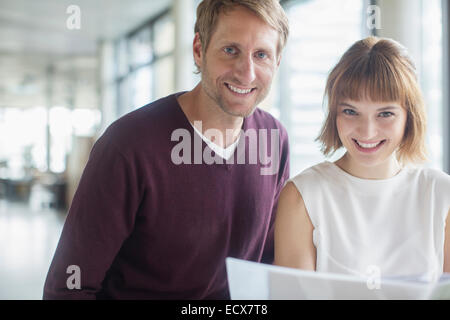 Geschäftsleute, die lächelnd im Büro Stockfoto