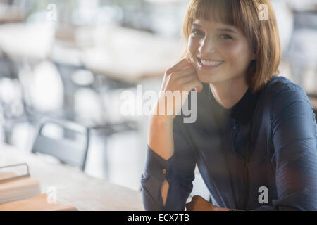 Geschäftsfrau, die lächelnd in cafeteria Stockfoto