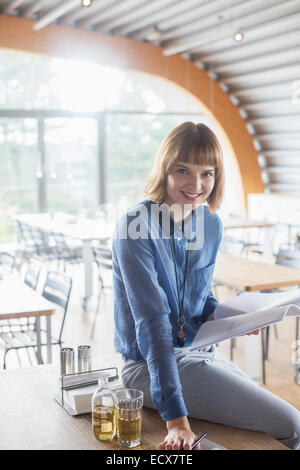 Geschäftsfrau, die lächelnd in cafeteria Stockfoto