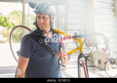 Mann mit Fahrrad auf Schulter Stockfoto