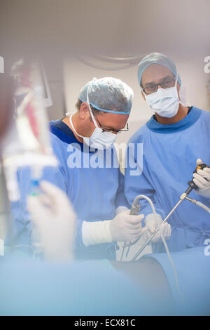 Ältere Ärzte Chirurgie und controlling Flüssigkeit in Kochsalzlösung Tasche Stockfoto