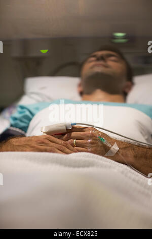 Männliche Patienten im Krankenhausbett schlafen Stockfoto
