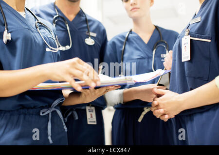 Ärzteteam mit Stethoskopen Blick auf Dokumente im Krankenhaus Stockfoto