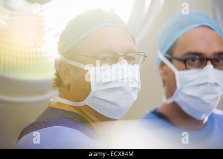 Porträt der beiden Ärzte tragen chirurgische Mützen, Masken und Brillen im Operationssaal Stockfoto