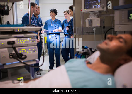 Patienten, die an medizinische Überwachungsgeräte auf Intensivstation, Ärzte in Tür stehe befestigt Stockfoto