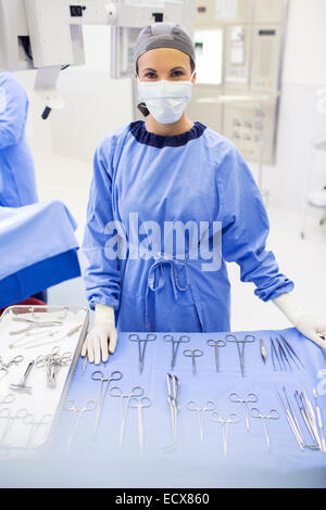 Porträt von OP-Schwester hinter medizinische Instrumente auf Tisch im Operationssaal Stockfoto