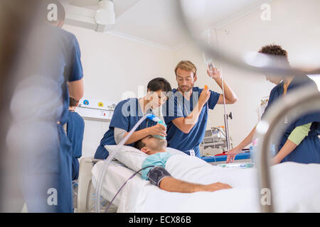 Arzt Holding Sauerstoffmaske über Patienten, männlichen Arzt anpassen Tropf Stockfoto