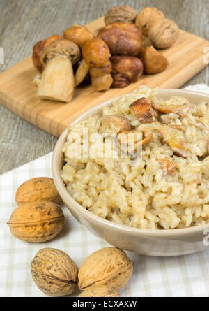 Risotto mit Steinpilzen auf Holztisch Stockfoto