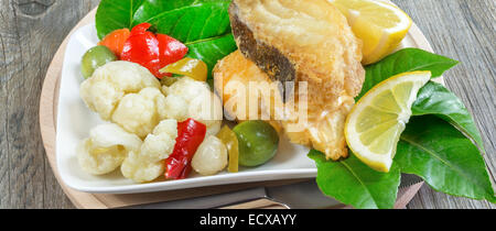 Stück Kabeljau gebraten auf Krautsalat Stockfoto